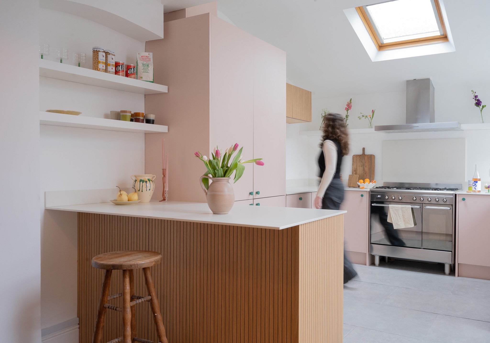 A bright kitchen with pink fronts and a white marble worktop.