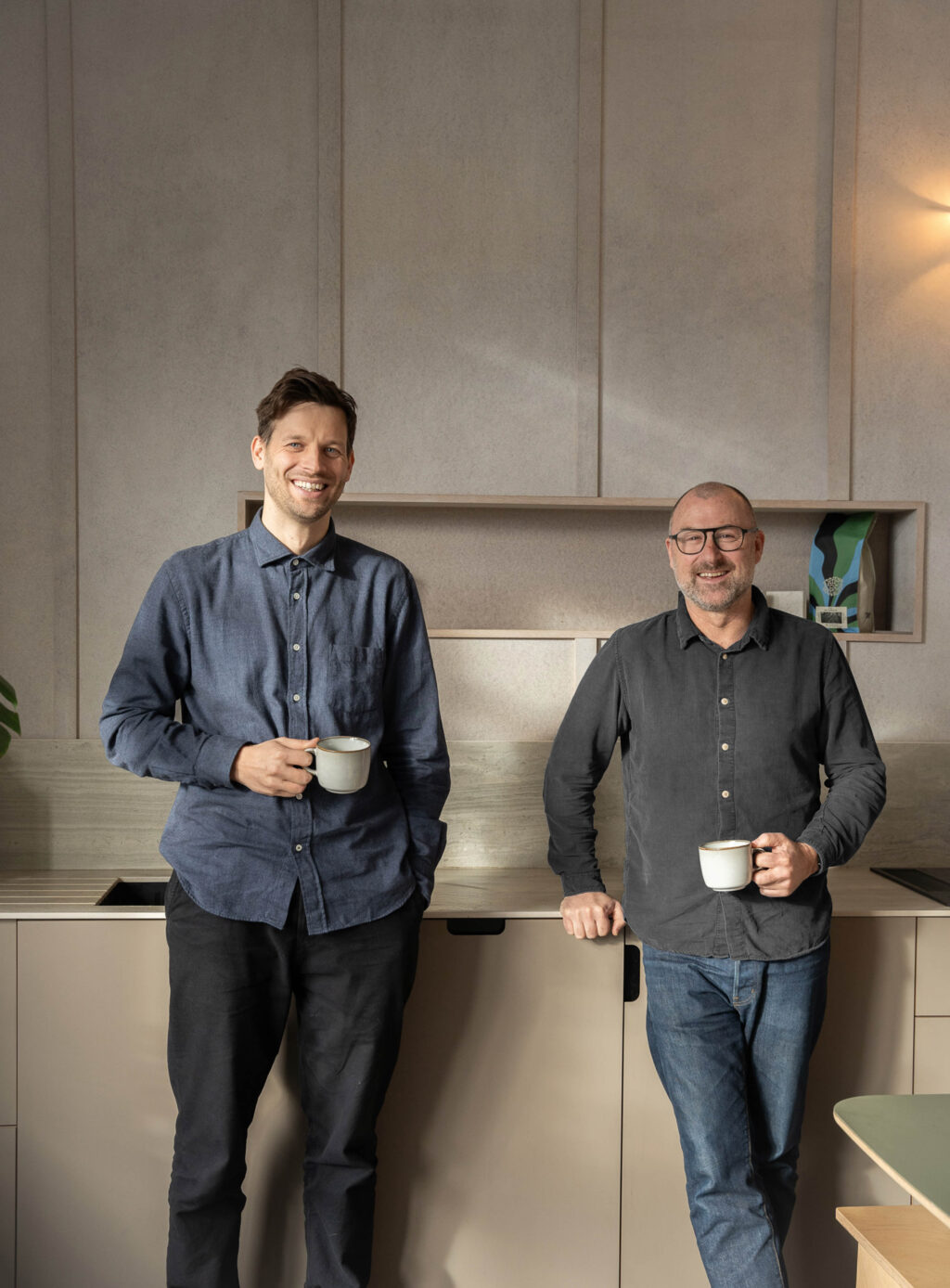 HUSK Founders Dave Young and Ross Norgate leaning on a kitchen counter with mugs of coffee