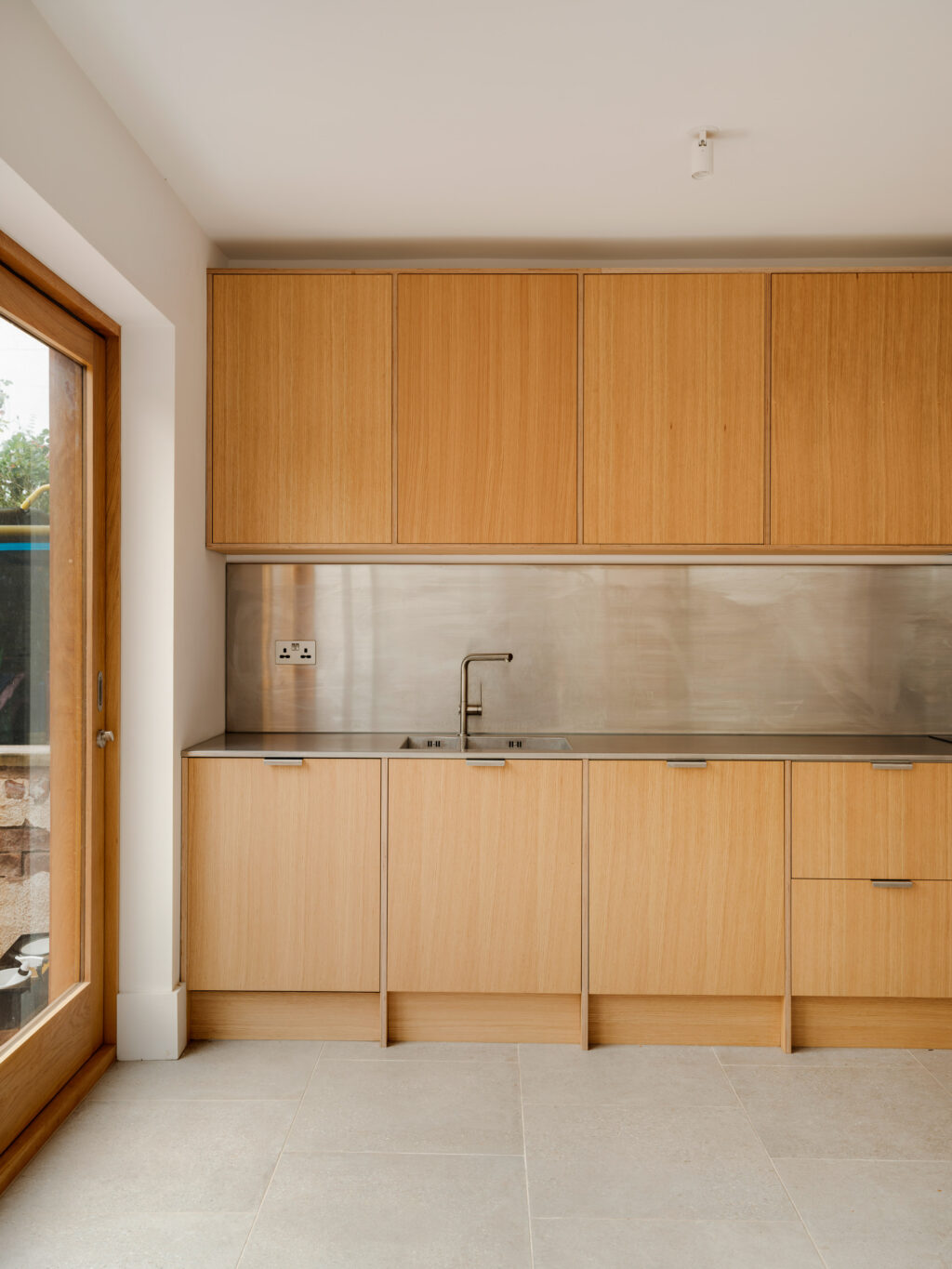 Modern Japandi kitchen featuring natural oak veneer cabinet fronts on ply and stainless steel worktop