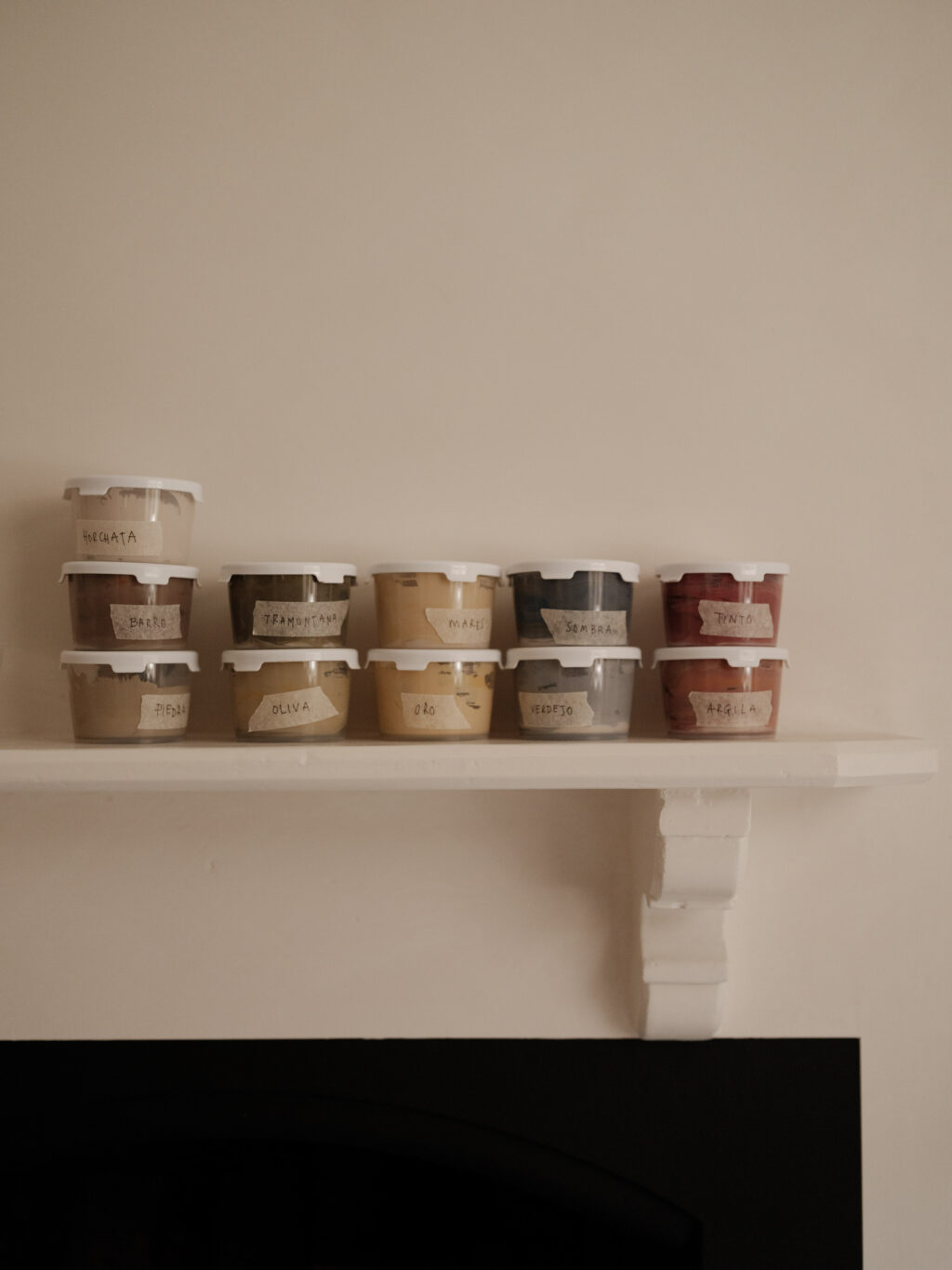 Labelled tubs of paint from the HUSK x Ro Projects collection arranged on a shelf