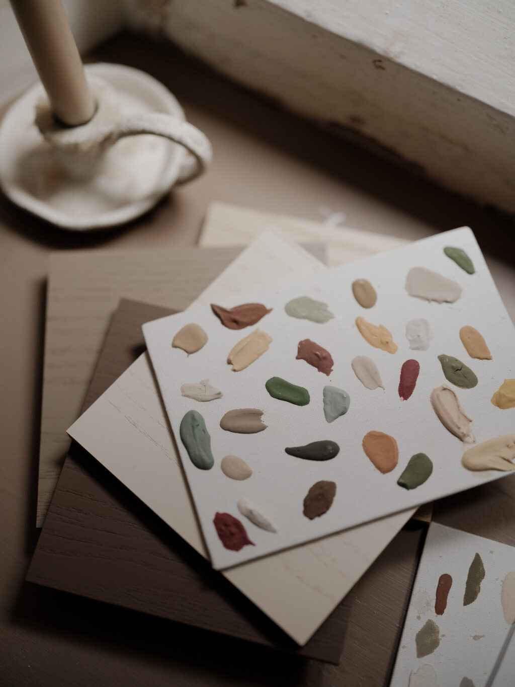 Painted card and timber material samples on a windowsill