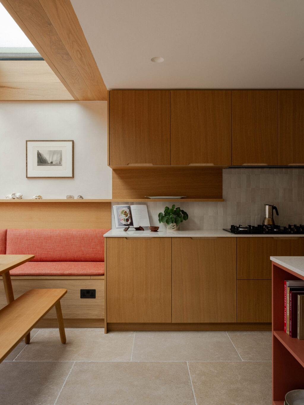 Natural Oak Veneer kitchen cabinetry with scallop handle detailing beside integrated banquette seating, zellige tiles and handcrafted wall shelf styling