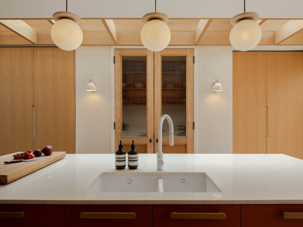 Symmetrical kitchen view featuring terrazzo island worktop, white tapware, Natural Oak Veneer cabinetry with ply edge and concealed pantry storage