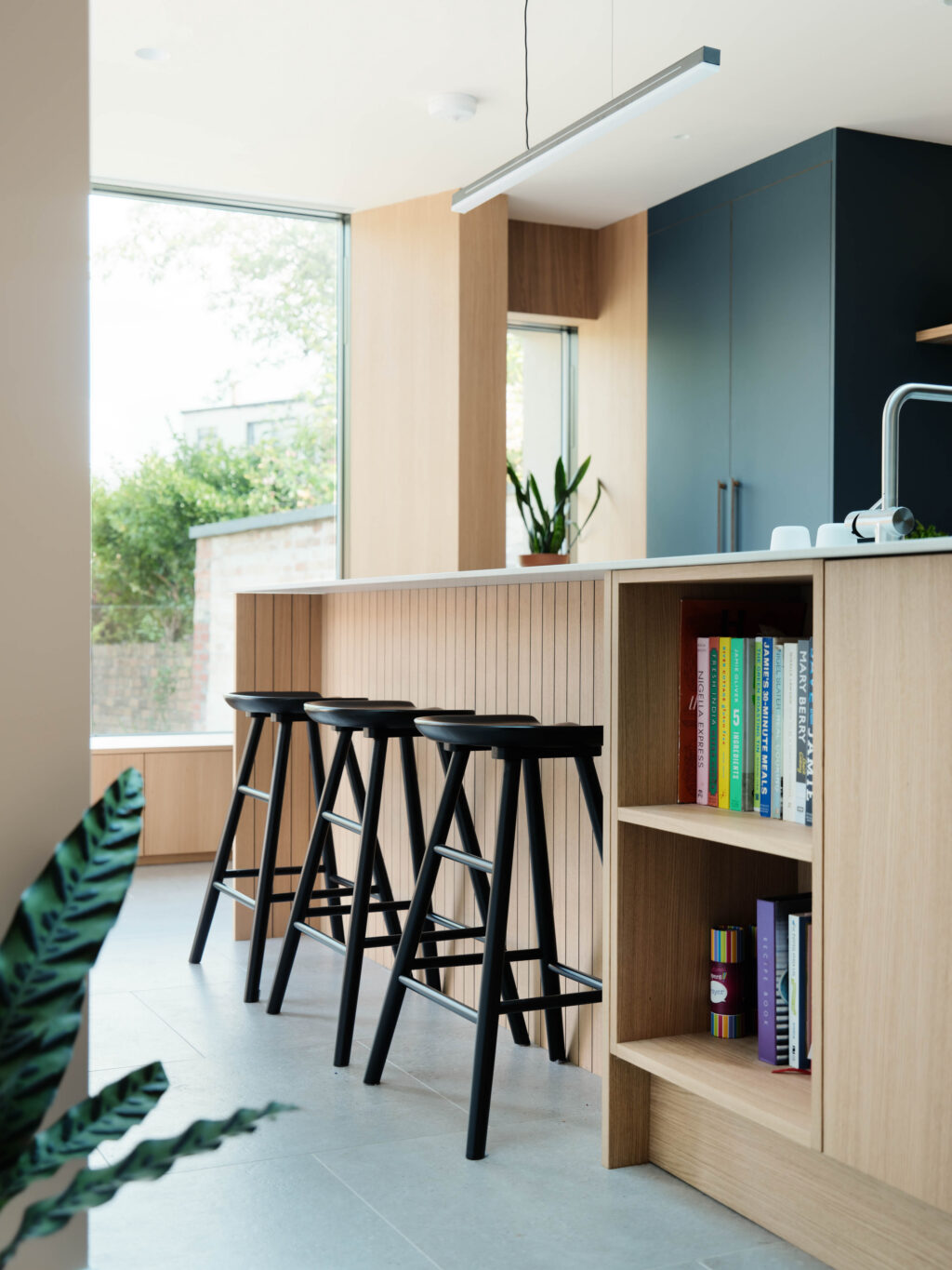 Oak kitchen island with open shelving, breakfast bar seating and HUSK oak pull bar handles