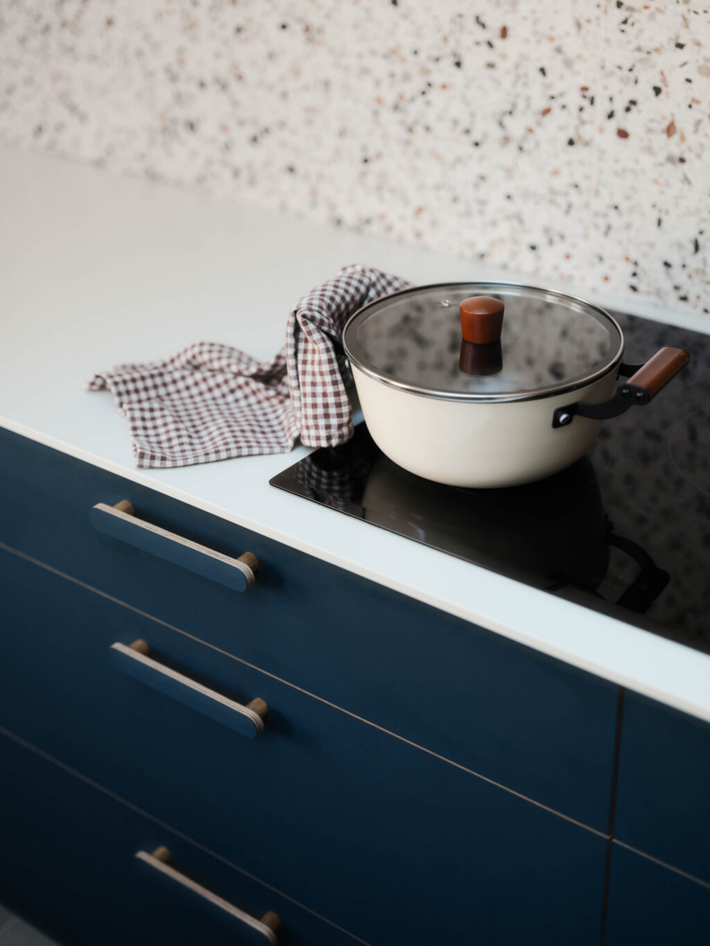 FENIX Blu Shaba cabinetry with integrated induction hob, Neolith Just White worktop and terrazzo-effect splashback