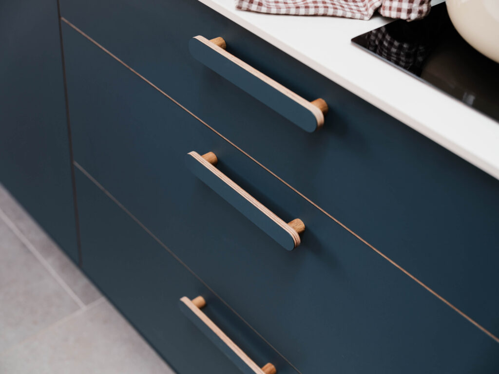Close-up of bespoke HUSK x Another Country oak handles mounted on FENIX Blu Shaba drawer fronts.