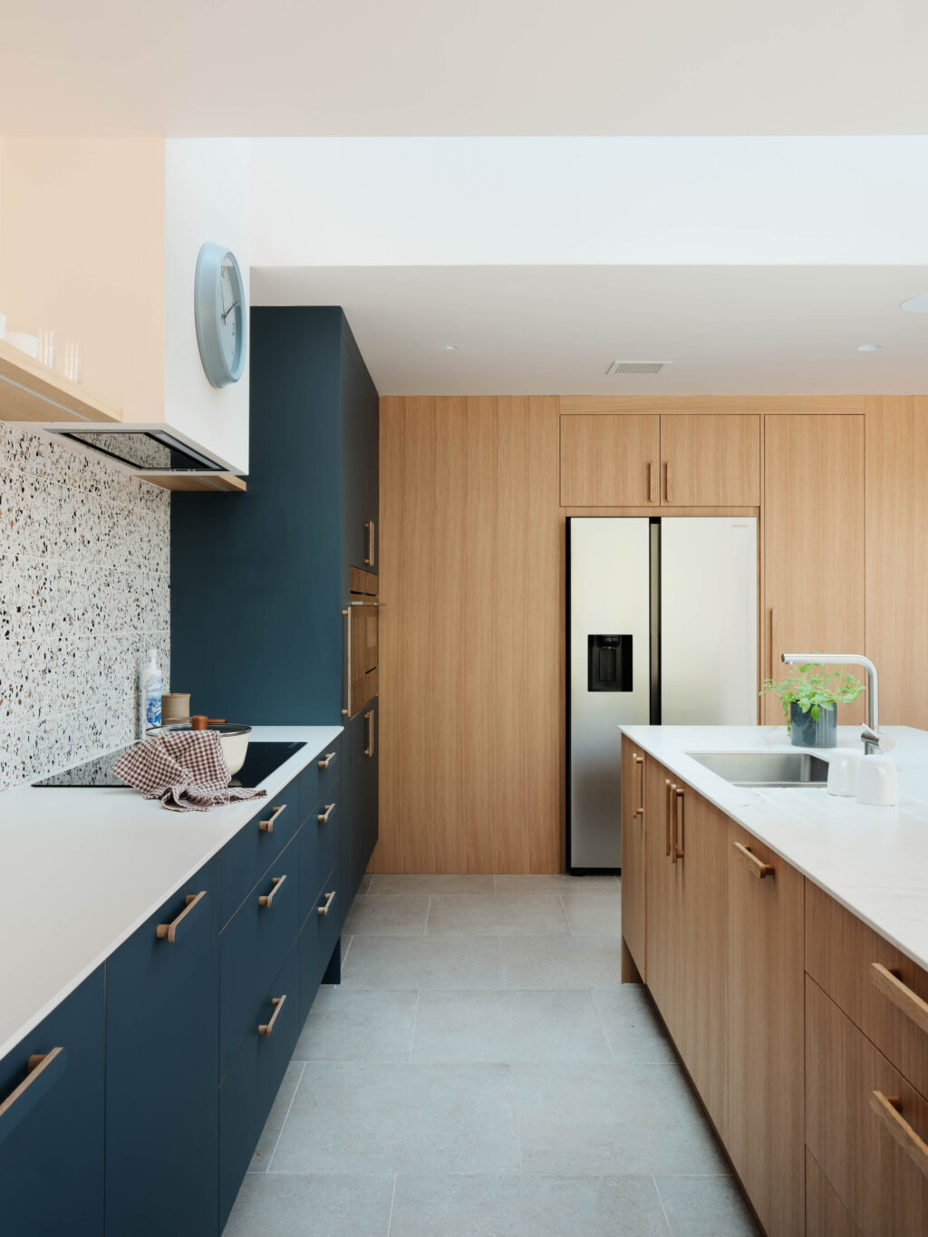 Bespoke kitchen with FENIX Blu Shaba cabinetry, natural oak timber veneer wall cabinetry, Neolith worktops and integrated appliances.