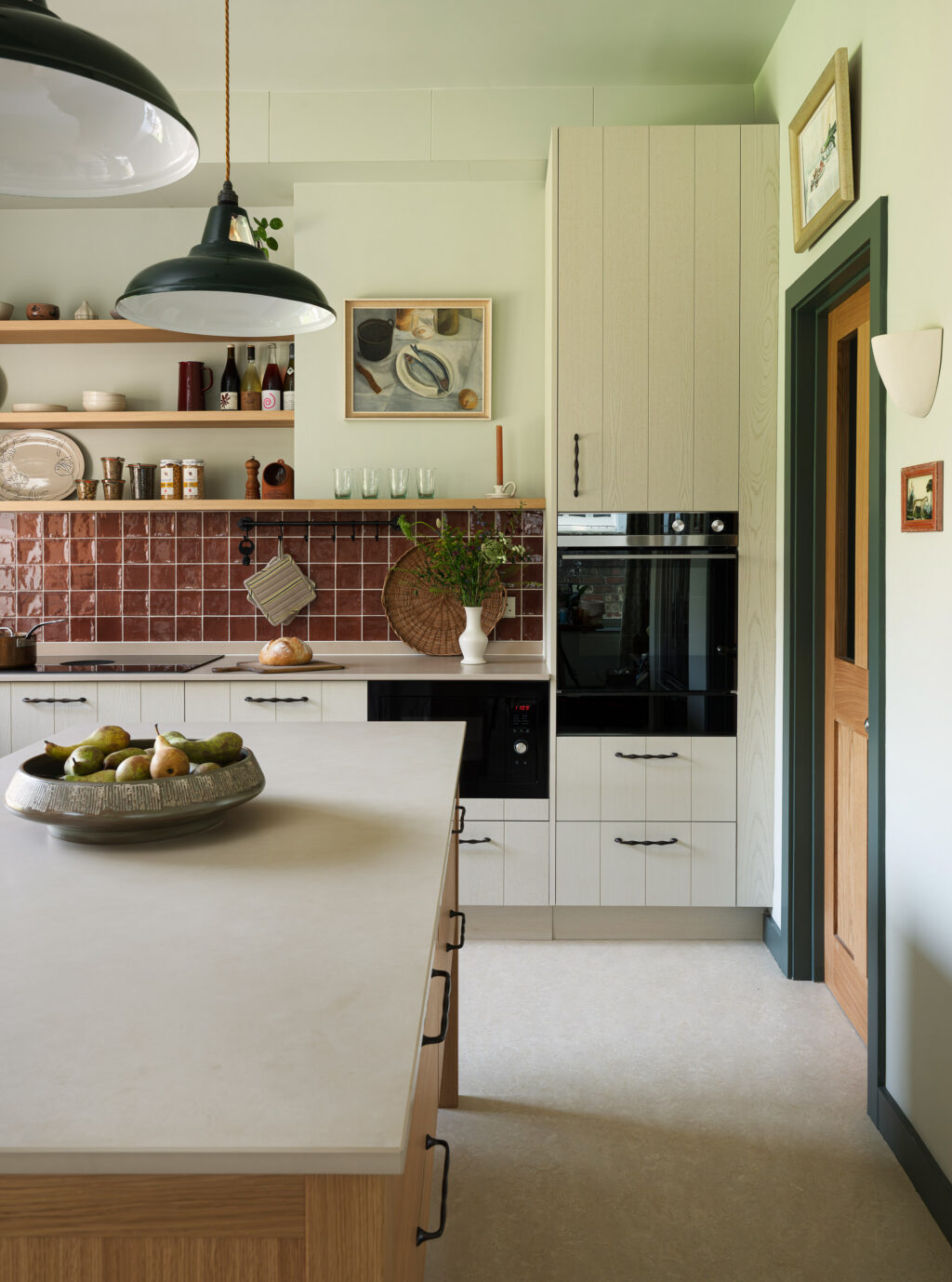 Kitchen appliance wall with integrated ovens, natural oak island and Purbeck Grey cabinetry