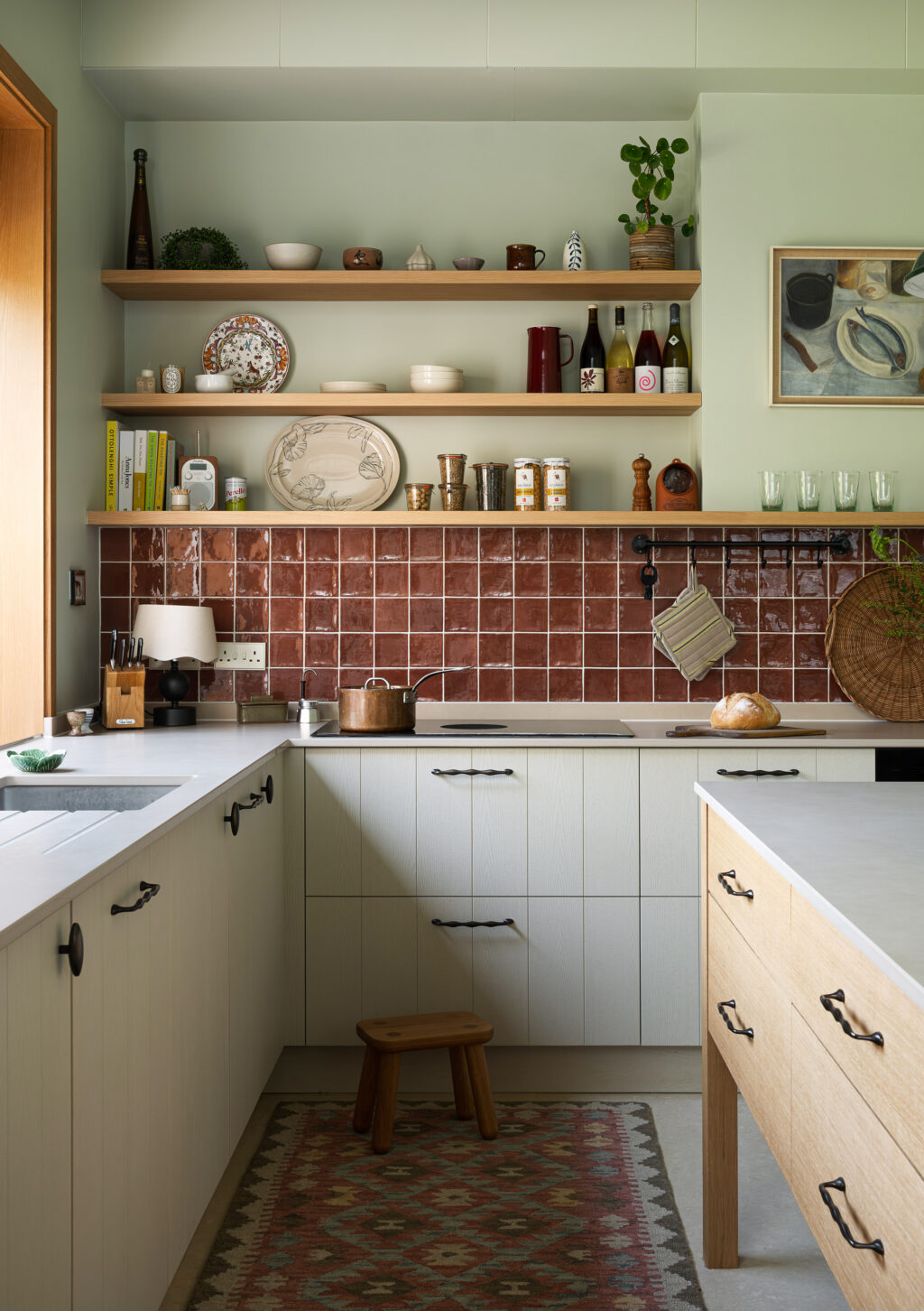Purbeck Grey kitchen featuring oak island, patterned runner rug, open oak shelving and terracotta splashback