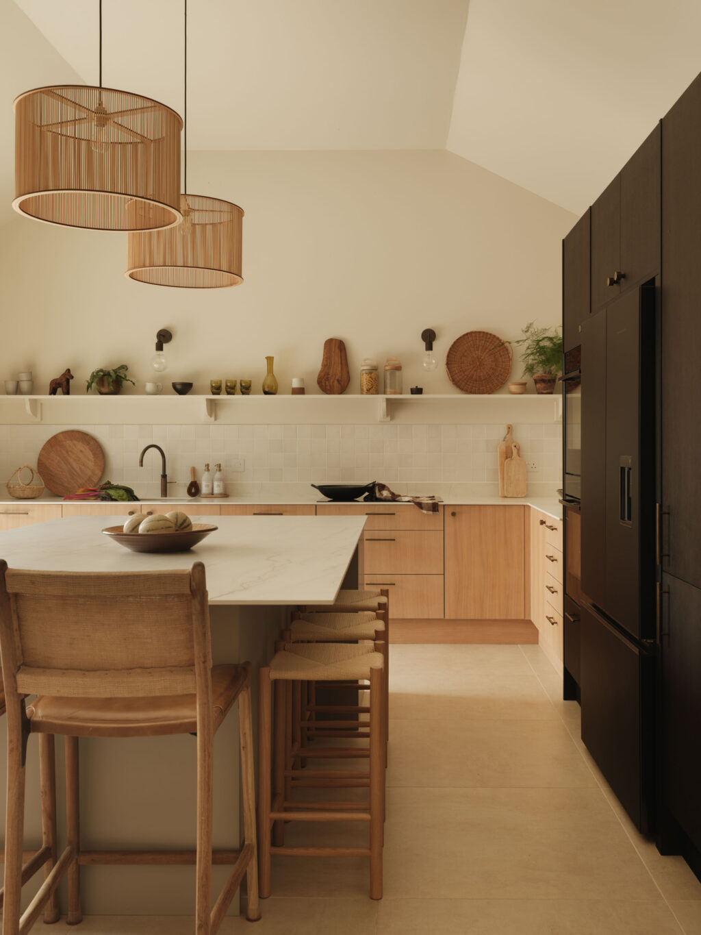 Corner view of White Tint Oak timber veneer kitchen cabinets with Plank Hardware handles, Neolith Mont Blanc worktops and tiled splashback.
