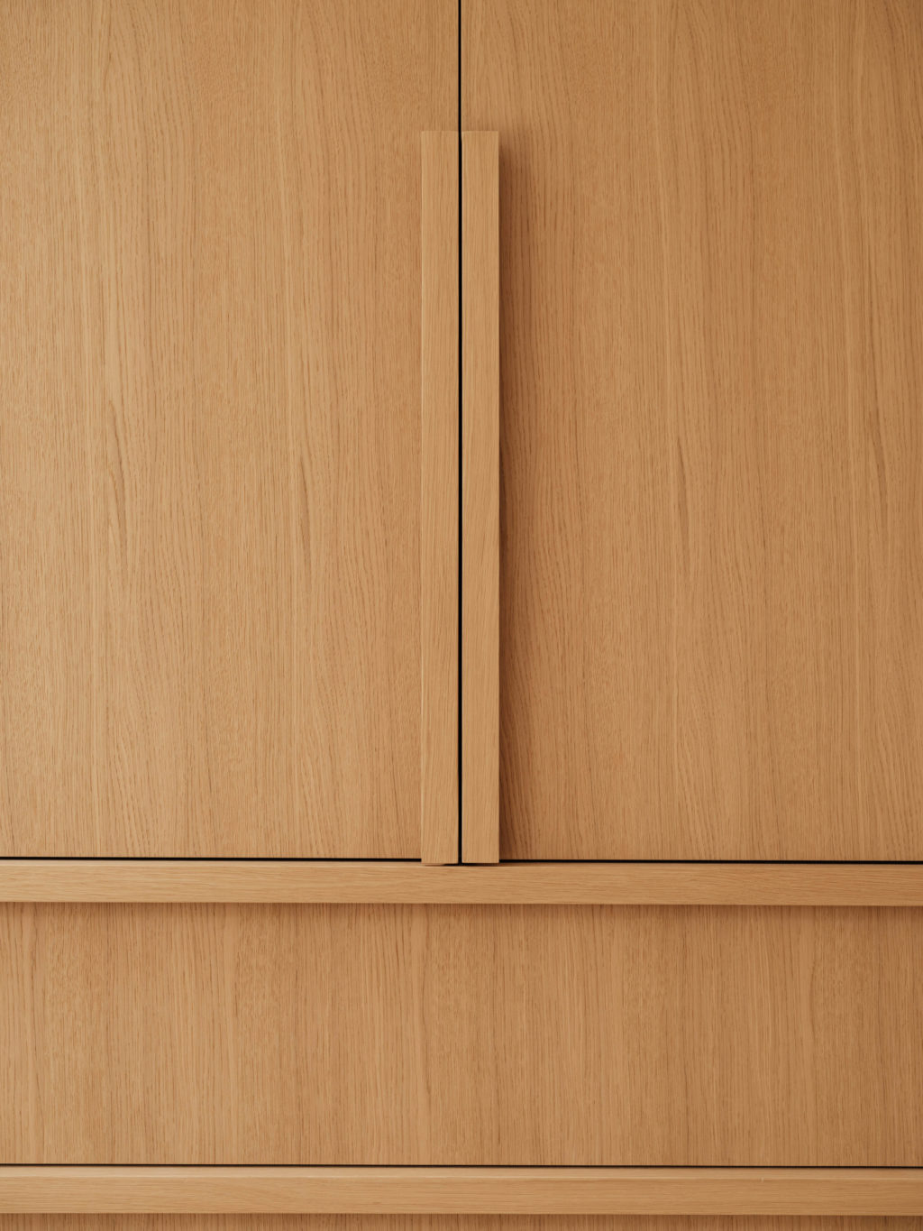 Close-up of Quarter Cut Natural Oak cabinet fronts showing the matching Solid Timber L Handles and vertical oak grain.