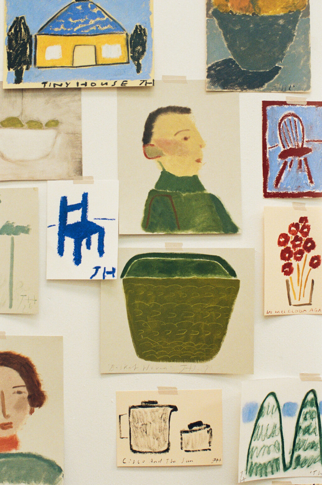 A collection of Jay Harper’s studies and sketches displayed on a studio wall, including portraits, chairs, flowers and houses.